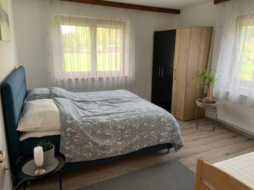 Schlafzimmer mit einem Bett, einem Tisch und Fenstern in der Unterkunft Haus Schmidl in Kötschach
