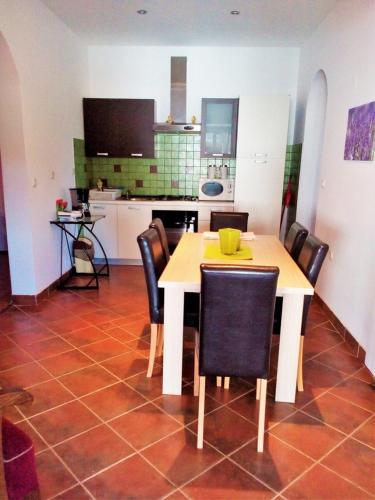 a kitchen with a white table and chairs and a table and a kitchen at Apartments Anto in Pula