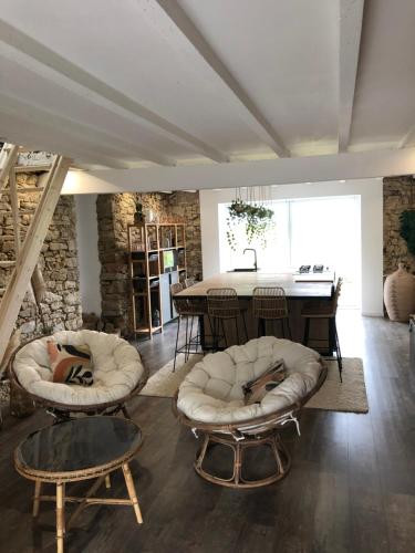 ein Wohnzimmer mit 2 Stühlen und einem Tisch in der Unterkunft La maison coup de cœur de Pont Caffino in Maisdon-sur-Sèvre