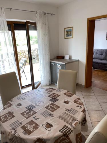 a dining room with a table with a tablecloth on it at Apartman Lidija in Linardići