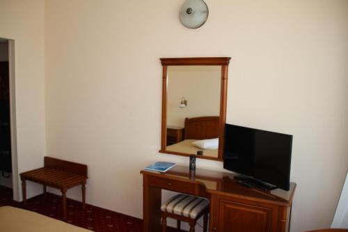 a hotel room with a tv and a mirror at Hotel Traian in Brăila