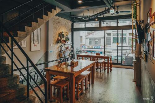 un ristorante con tavoli e sedie in legno e una scala di Chia Kon Hotel a Città di Chiayi