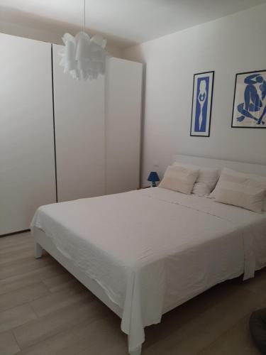 a white bedroom with a large white bed at Casa del Leccio in Pulsano