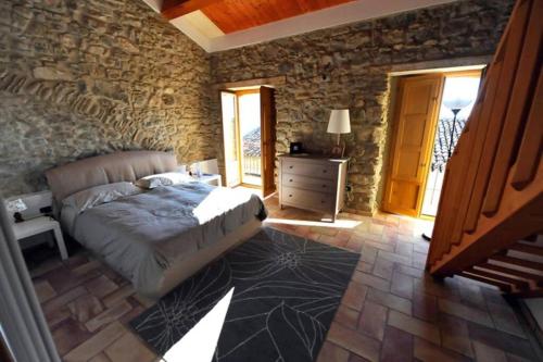 um quarto com uma cama e uma parede de pedra em casa storica em Francavilla Marittima