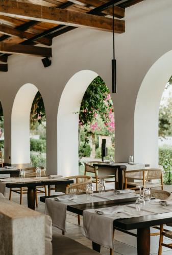 a restaurant with tables and chairs and arches at Minos Beach Art Hotel, a Member of Design Hotels in Agios Nikolaos