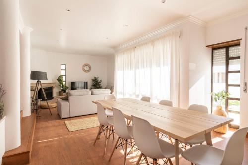 a living room with a wooden table and chairs at Ericeira Paradise House&Suites in Ericeira