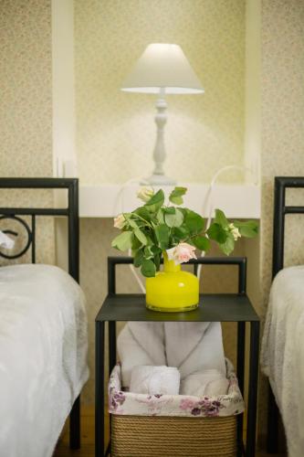 a table with a potted plant on it next to two beds at Nino's House in Tsinandali