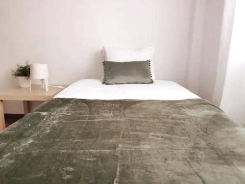 a bed in a small room with a table at cosy2bedroomapartment in Loulé
