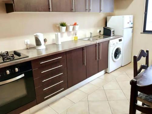 a kitchen with a sink and a stove and a dishwasher at cosy2bedroomapartment in Loulé