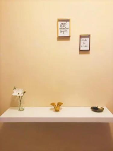 a shelf with two pictures and a vase with flowers on it at cosy2bedroomapartment in Loulé