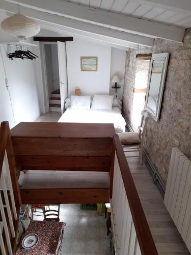 - une chambre avec un lit et des escaliers dans l'établissement Treille, à Sainte-Marie de Ré
