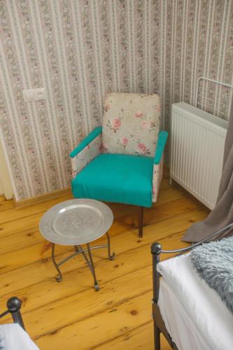a room with a chair and a table and a bed at Nino's House in Tsinandali