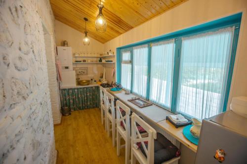 eine Küche mit einer langen Theke mit Stühlen darin in der Unterkunft Nino's House in Tsinandali