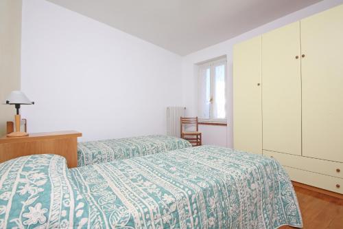 a bedroom with two beds and a dresser at Apartment Casa Caterina in Gargnano