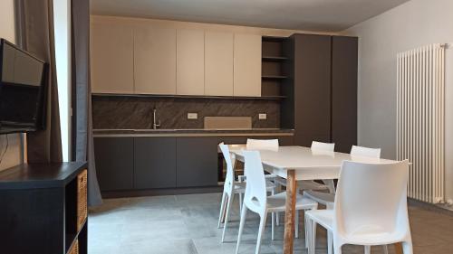 a kitchen and dining room with a table and chairs at Il Fouia Apartments in Pragelato