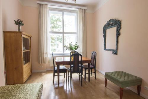 uma sala de jantar com uma mesa e cadeiras e uma janela em Prague Castle apartment Vintage em Praga