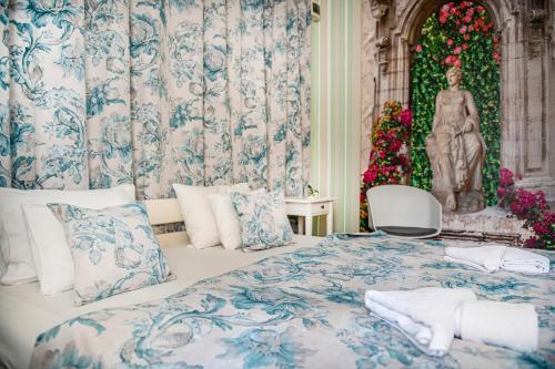 a bedroom with a bed with a statue of a woman at Tündérkert Hotel Noszvaj in Noszvaj