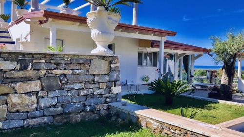 a house with a stone wall in front of it at L'incanto di Nausicaa in Ascea