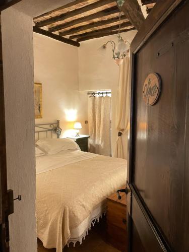a bedroom with a bed with a white bedspread at Guesthouse da Idolina dal 1946 in Montalcino
