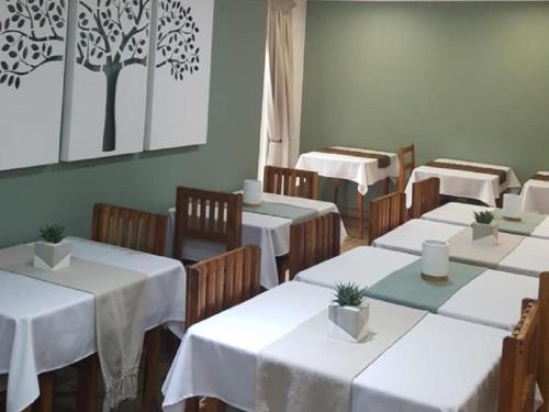 a dining room with white tables and wooden chairs at Euforia Guesthouse in Middelburg