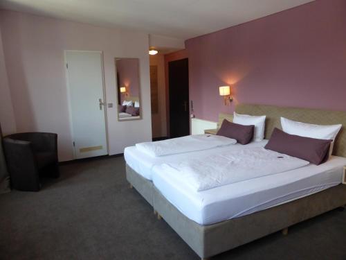ein Schlafzimmer mit einem großen weißen Bett mit lila Wänden in der Unterkunft Rheinhotel Zur Krone in Boppard