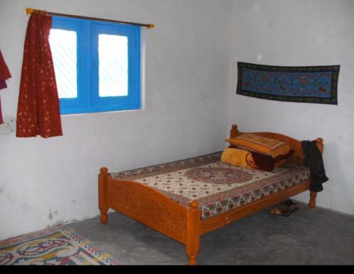 a small bed in a room with a window at Vamoose Bablu in Khajurāho