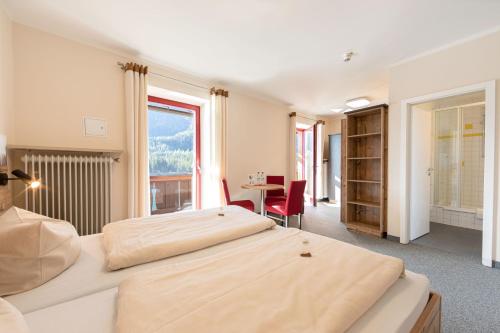 two beds in a room with a table and a desk at ALPEN EXPERIENCE - CVJM Aktivzentrum Hintersee, Jugendgästehaus in Ramsau