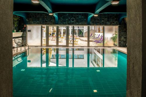 an indoor swimming pool with a view of the water at Tündérkert Hotel Noszvaj in Noszvaj