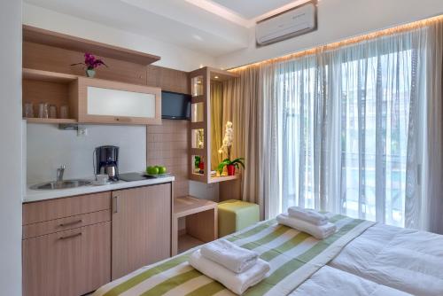 1 dormitorio con cama, lavabo y ventana en Leonidas Hotel & Apartments, en Rethymno