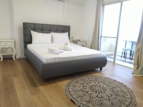 a bedroom with a bed with white sheets and a rug at Dekel-City center and Sea view -new listing in Eilat
