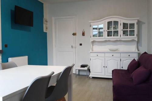 un salon avec une table blanche et un canapé dans l'établissement Apt T2 41m2 WIFI 2* 4-6 pers. La BOURBOULE, à La Bourboule