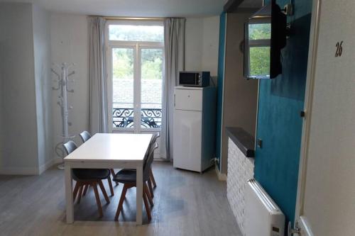 une cuisine avec une table et des chaises et une fenêtre dans l'établissement Apt T2 41m2 WIFI 2* 4-6 pers. La BOURBOULE, à La Bourboule