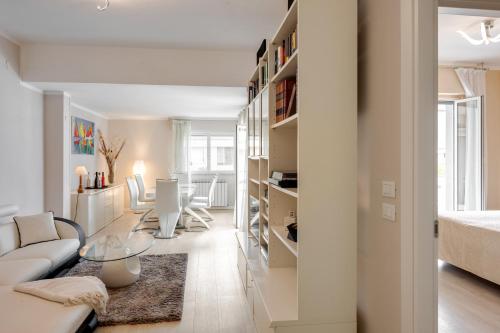 Sala de estar blanca con sofá y mesa en Luni Mare Bright Terrace Flat with Parking, en Marinella di Sarzana