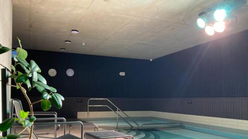 a swimming pool with chairs in a blue wall at OTTO Hotel & Sun in Pāvilosta