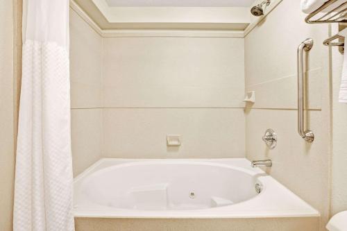 a white bath tub in a bathroom with a shower at Days Inn by Wyndham Oklahoma City/Moore in Oklahoma City