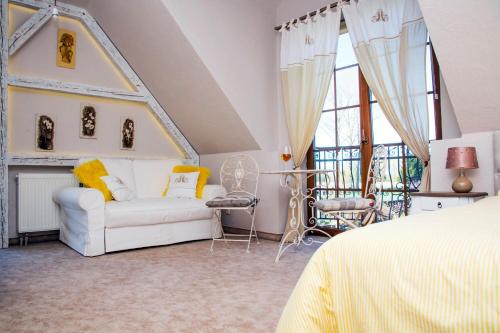 a bedroom with a white couch and a chair at Feniks Agro&Spa Adults Only in Świnoujście