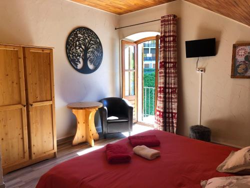 a bedroom with a bed with a red blanket and a window at Hôtel, Le Refuge Napoléon in Vars