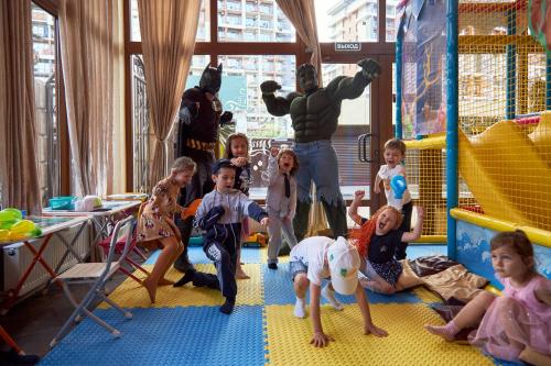 un grupo de niños jugando en un parque infantil interior en Отель Колизей, en Dagomys
