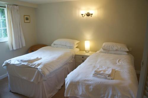 dos camas sentadas una al lado de la otra en un dormitorio en Minehead mews cottage en Minehead