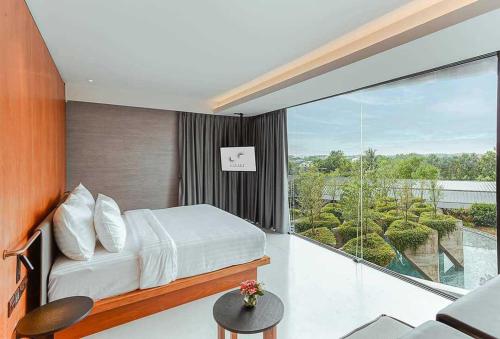 a bedroom with a bed and a large window at Livist Resort phetchabun in Phetchabun