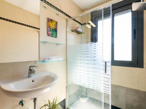 a bathroom with a sink and a glass shower at Apartamento LABORT in Cádiz