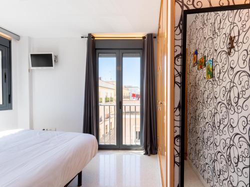 a bedroom with a bed and a sliding glass door at Apartamento LABORT in Cádiz