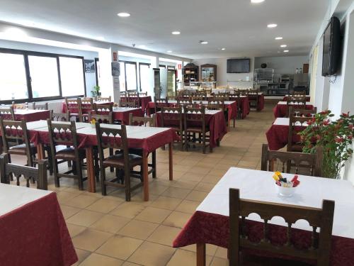 a restaurant with tables and chairs with red table cloth at Hotel Refugi dels Isards in Pas de la Casa