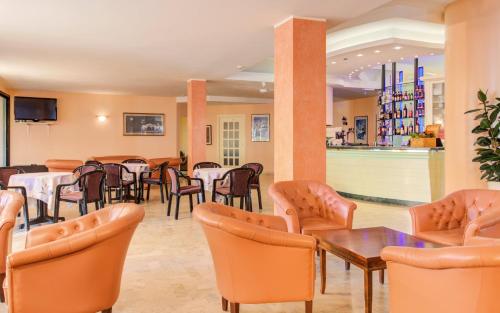 um restaurante com mesas e cadeiras e um bar em Hotel Spiaggia em Gatteo a Mare