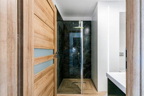 a pivot door in a bathroom with a shower at Apartament Zielony OPTILOCUS in Gdańsk