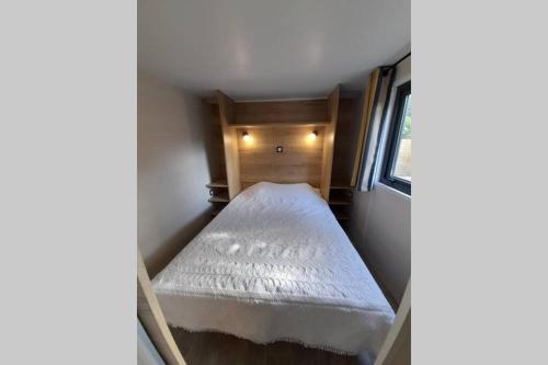 ein kleines Schlafzimmer mit einem Bett in einem kleinen Zimmer in der Unterkunft Maison Tiny House 2 chambres Soulac a 500m plage in Soulac-sur-Mer