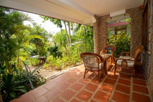 an outdoor patio with chairs and a table at TARA LODGE Haven of peace in Kep