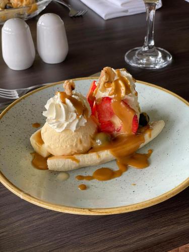 a plate with ice cream and fruit on a table at The Inn At Charlestown in Dunfermline