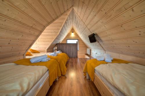a room with three beds in a attic at Widokowe Domki Gawlaki in Zakopane