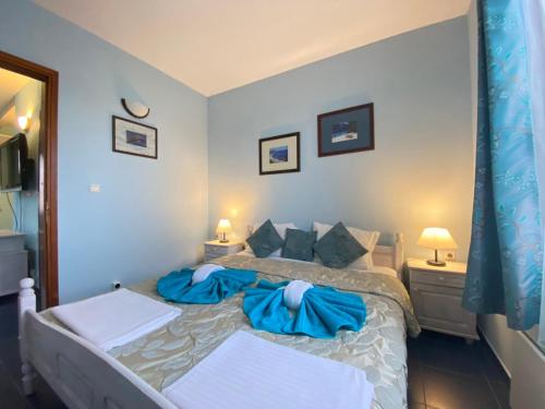 a bedroom with a large bed with blue sheets at Villas and Bungalows Panorama in Chernomorets